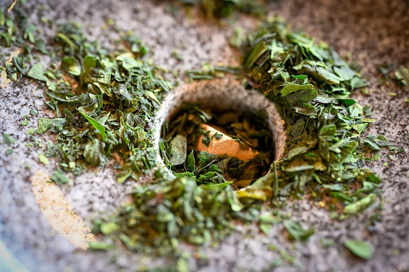 Dried tencha leaves in the opening of a stone mill