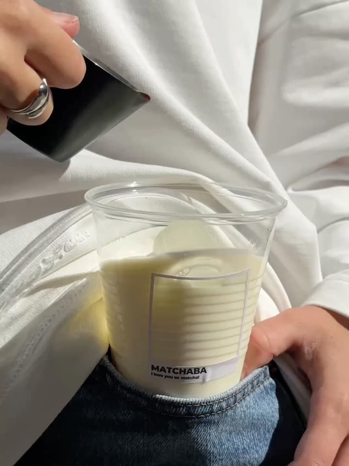 A drink poured into a cup of milk and ice with the MatchaBa label