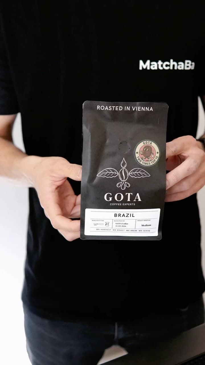 A bag of GOTA coffee held up in front of a MatchaBa shirt