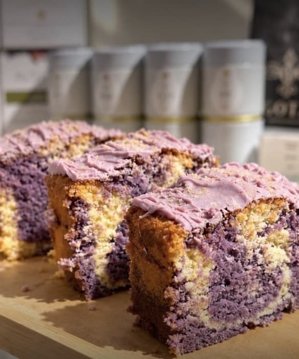 Slices of purple marbled ube cake on a wooden board