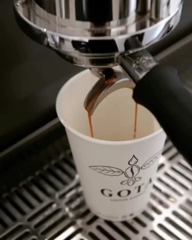 An espresso from GOTA beans running into a GOTA cup