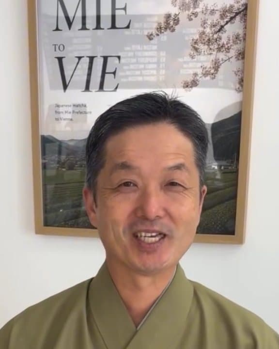 Hagimura-san smiling in front of the Mie to Vie poster, then whisking matcha and pouring it into small cups